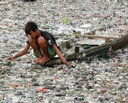 20 Mar 2007, Jakarta, Indonesia --- A  young Indonesian boy collects plastics from a raft from a  polluted river in Jakarta. The Indonesian government predicts that the total number of Indonesia's unemployed will rise by one million this year from last year's figure of 10.8 million people. The government said it is optimistic that 1.5 million new jobs will be created this year, but this figure will not be enough to swallow up all of the 2.5 million job seekers.   --- Image by Â© Jurnasyanto Sukarno/epa/Corbis